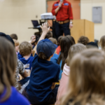 Woman speaking to a group of kids